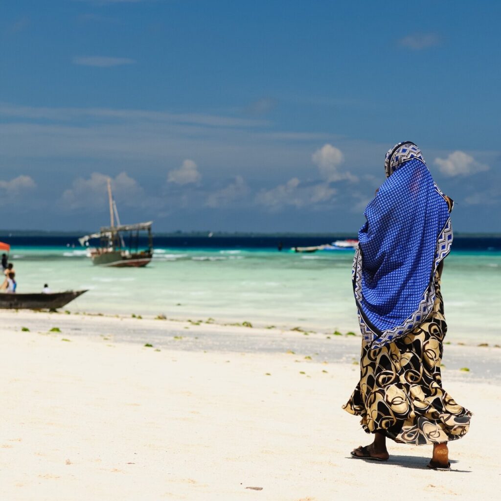 A woman walking through the beach in Tanzania